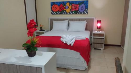 um quarto com uma cama com um cobertor vermelho em Solar Pipa Flats em Pipa