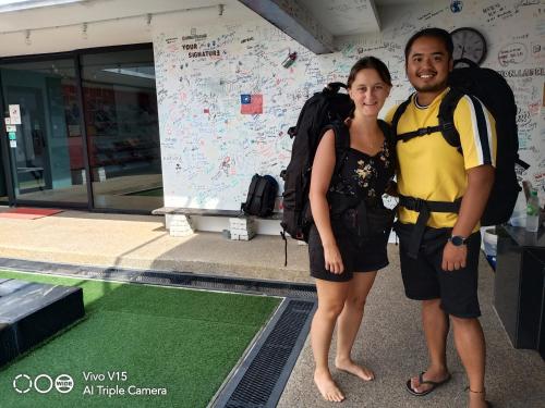 a man and a woman with backpacks posing for a picture at Beds In Garden Hostel in Ipoh