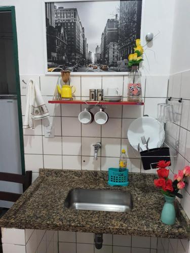 um balcão de cozinha com um lavatório e uma janela em suite 02 - privativa, aconchegante e independente em Cuiabá