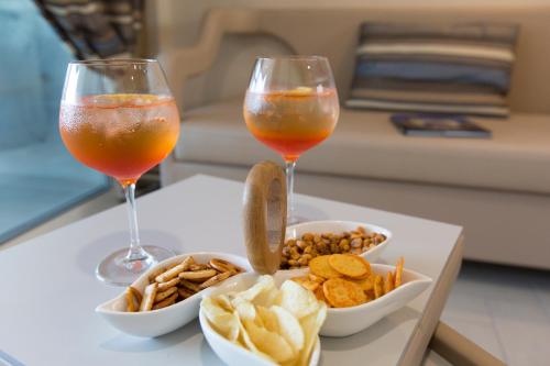 two glasses of drinks and snacks on a table at Nero D'Avorio Aparthotel & SPA in Rimini