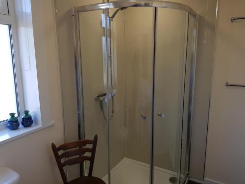a shower with a glass door in a bathroom at Glenduron-by-Sea in Saint Marys