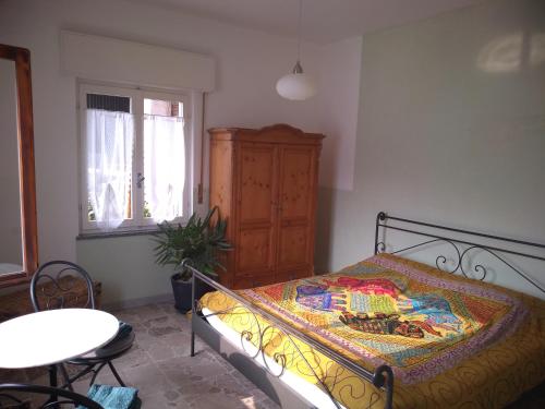 a bedroom with a bed and a table and a window at Casa Lago Azzurro Apartement in Cannobio