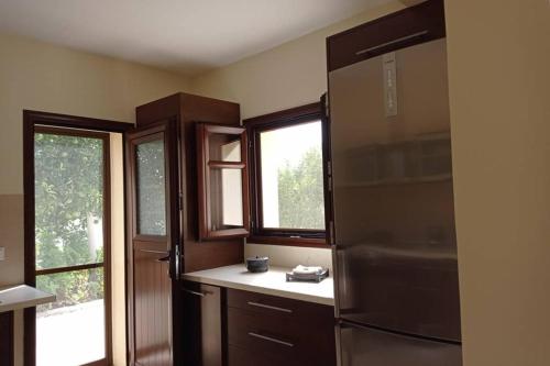 a kitchen with a refrigerator and some windows at Afroditis's & Makis's apartment in Leonidio