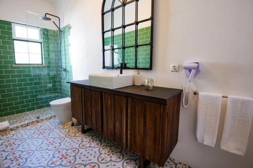 a bathroom with a sink and a toilet and a mirror at Villa Eira in Vila Nova de Milfontes