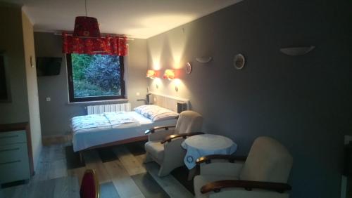 Zimmer mit 2 Betten und Stühlen sowie einem Fenster in der Unterkunft Miodowy Raj in Targanice