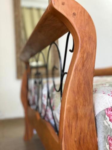 a close up of a wooden bed with a wooden frame at POUSADA CHARLOTTE in Tiradentes