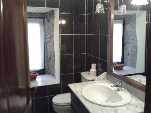 a bathroom with a sink and a toilet and a mirror at Casa Dos Gaios in Vieira do Minho