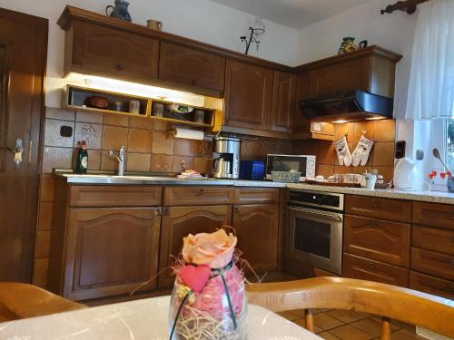 a kitchen with wooden cabinets and a table with a table sidx sidx at Gästehaus Aurelia in Wiesau