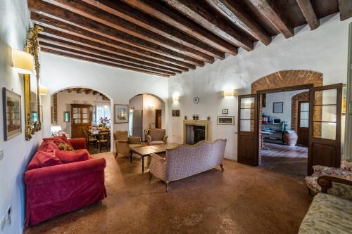 a living room with a red couch and a table at Agriturismo Tenuta Castel Venezze in San Martino di Venezze