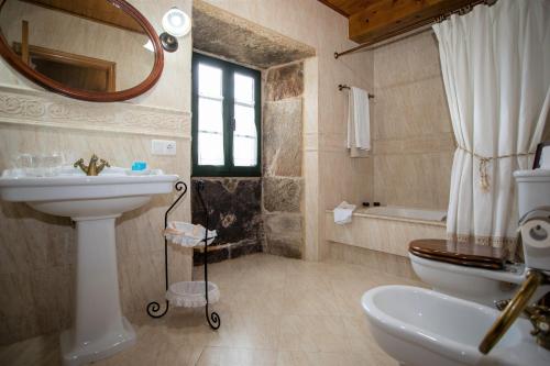Teijeiro的住宿－巴雷羅度假屋，一间带水槽、卫生间和镜子的浴室