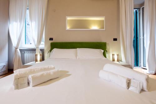 a bedroom with a large white bed with two windows at Magenta Collection Crociferi 3 in Rome