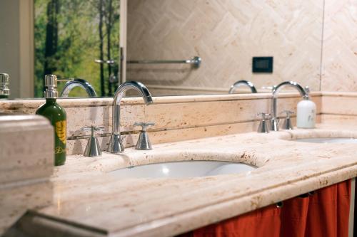 Un mostrador de baño con dos lavabos y un espejo. en Magenta Collection Crociferi 3, en Roma