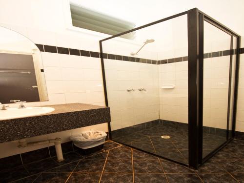 a bathroom with a shower and a sink at Peden's Hotel in Cessnock
