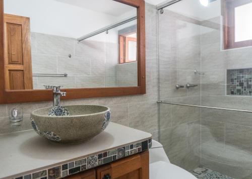 Un baño con lavabo y ducha de cristal. en Apartamento Madeiro, en Villa de Leyva