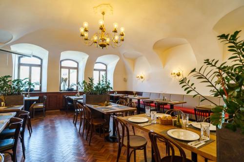un restaurante con mesas y sillas y una lámpara de araña en Hotel U Labutě, en Žďár nad Sázavou