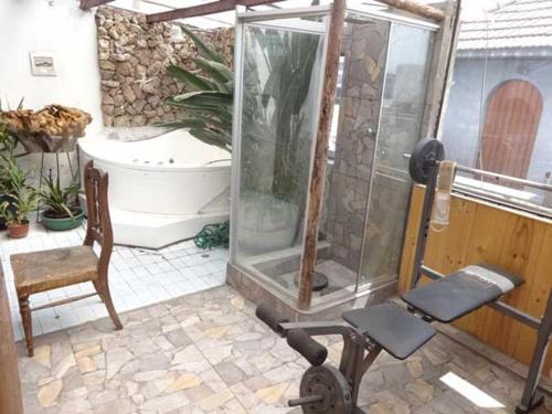 a bathroom with a shower and a chair and a tub at Hostal Paris in Arequipa