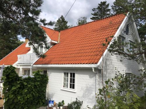a white house with an orange roof at Leilighet i Sørlandshus i Son - Sjøutsikt - Nær Son Spa in Son