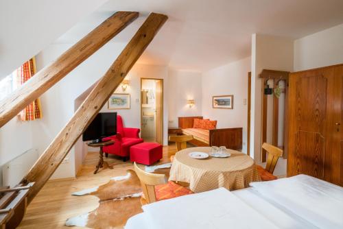 ein Wohnzimmer mit einem Tisch und ein Schlafzimmer in der Unterkunft Hotel Oremushof in Velden am Wörthersee