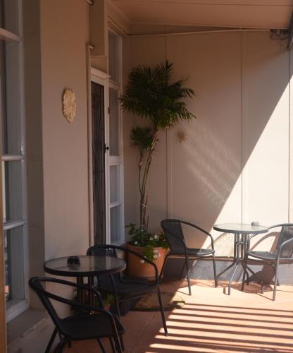 a patio with tables and chairs and a potted plant at Clifton Motel in Albury