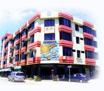 a large building with cars parked in front of it at Hotel Arena Caliente in Playas