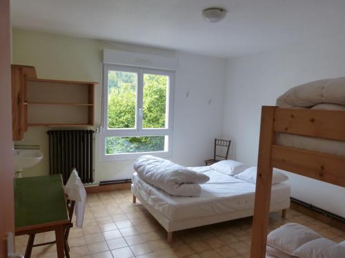 Ban-sur-Meurthe-ClefcyにあるLa Saucéeのベッドルーム1室(二段ベッド2台、窓付)が備わります。