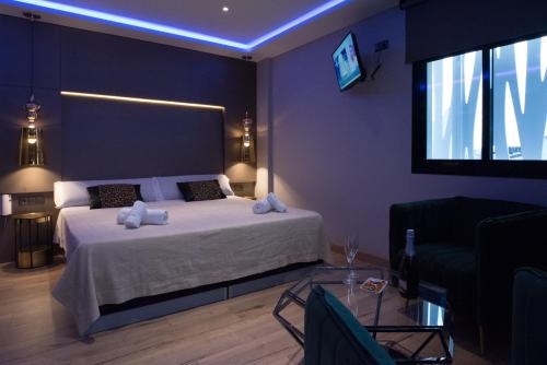 a bedroom with a bed and a tv on the wall at DAOS Suites & Terrace Marbella in Marbella