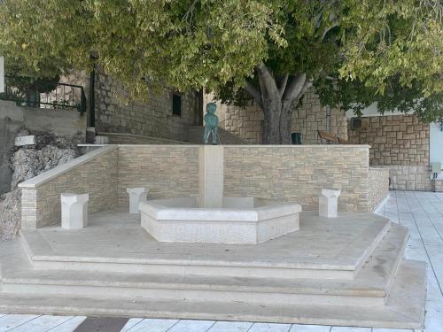a statue sitting in front of a brick wall at Apartments Grozdana in Gradac