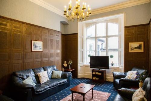 a living room with two couches and a television at The Burlington Hotel in Torquay