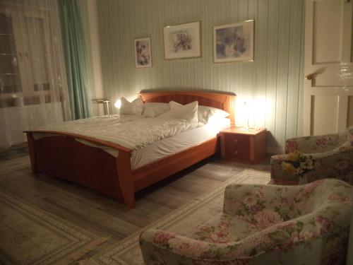 sypialnia z łóżkiem i 2 krzesłami w obiekcie Maria Apartman w Hévízie