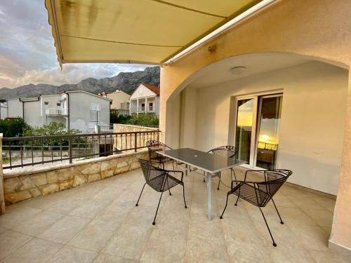 a patio with a table and chairs on a balcony at Apartments Grozdana in Gradac