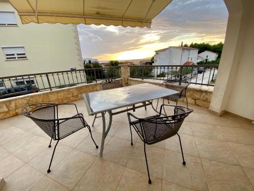 a table and chairs on a balcony with a view at Apartments Grozdana in Gradac