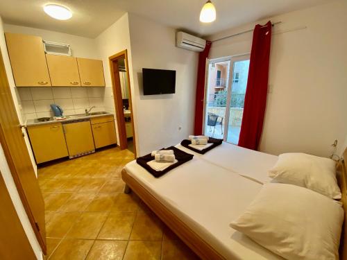 a bedroom with a large bed and a kitchen at Apartments Grozdana in Gradac