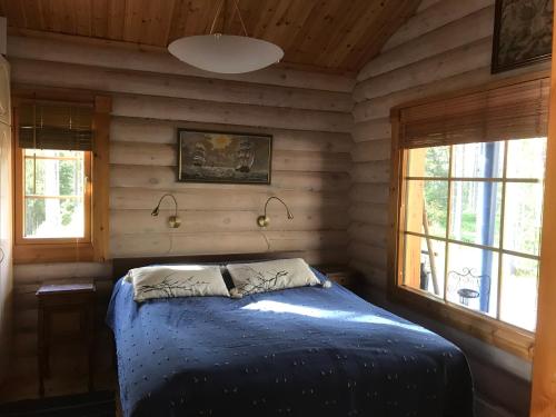 a bedroom with a bed in a log cabin at Chalet Ahma in Jurmu