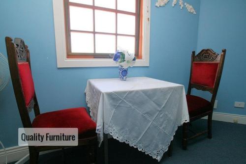 a table with a vase on it with two chairs at Hatchers Richmond Manor in Richmond