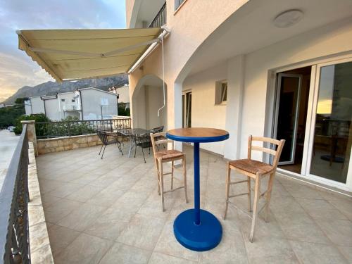 a table and chairs on the balcony of a house at Apartments Grozdana in Gradac