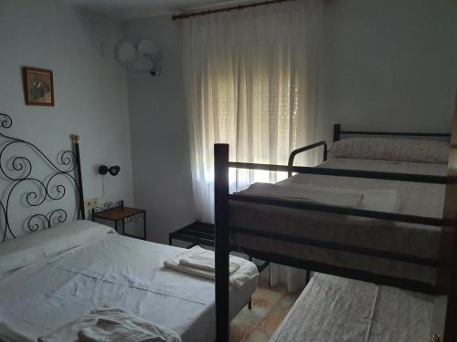 1 Schlafzimmer mit 2 Etagenbetten und einem Fenster in der Unterkunft CHalet aeropuerto Sevilla in Sevilla