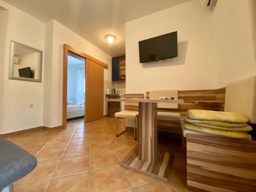 a living room with a table and a television on the wall at Apartments Grozdana in Gradac