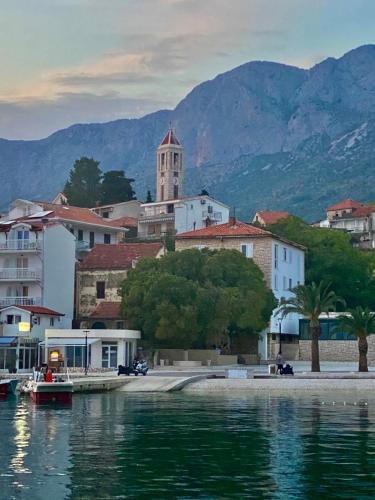 a small boat on the water in front of a city at Apartments Grozdana in Gradac