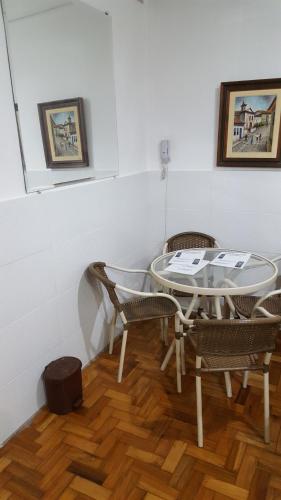 a table and chairs in a room with white walls at Comodidade e Segurança no Centro in Belo Horizonte
