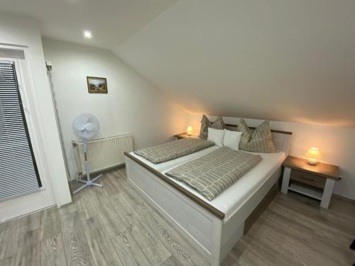 una camera con letto, ventilatore e finestra di Ossiach Apartment 2 a Heiligen Gestade