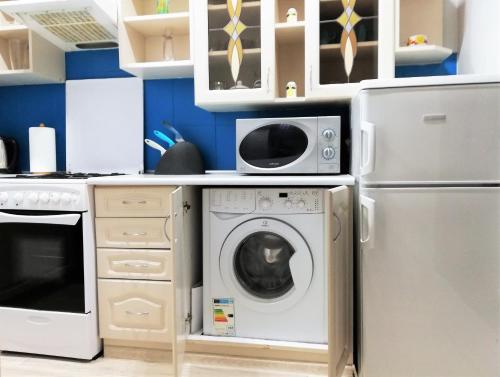 a kitchen with a washing machine and a refrigerator at Apartamenty Copernicus - zameldowanie 24 h in Toruń