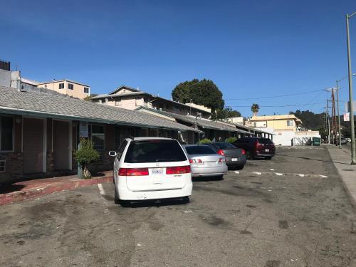 uma fila de carros estacionados num parque de estacionamento em Commodore Motel em Oakland