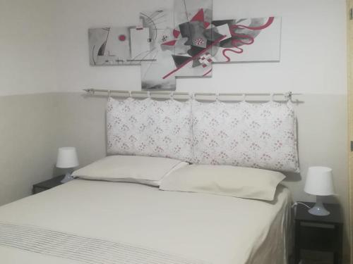 - une chambre avec un lit blanc et 2 oreillers dans l'établissement Casa nonna Angelina, à Bisceglie
