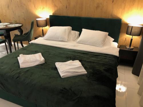 een slaapkamer met een groot bed en 2 handdoeken bij GREEN 25 - Angel River in Wrocław