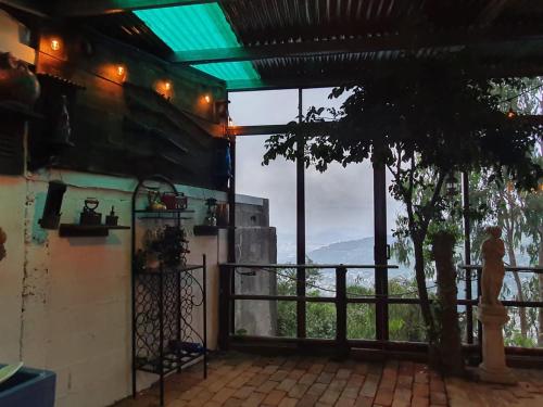 a room with a view of a tree and a balcony at Cabaña Cielo y Luna in Planes de Renderos