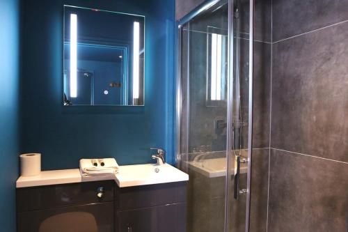 a bathroom with a shower and a sink and a mirror at The Cherry Rooms in London