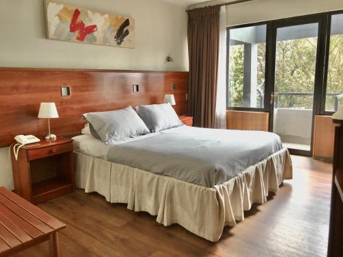 KU Hotel Turismo Temuco tesisinde bir odada yatak veya yataklar