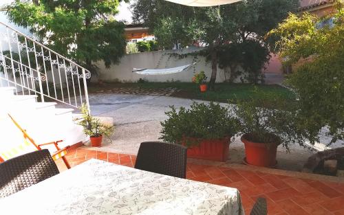 un patio con mesa, sillas y una valla en Casa al mare La Palma, en Santa Maria Navarrese