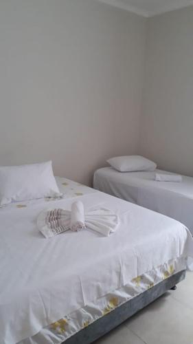 two beds with white sheets and towels on them at Pousada Canoa de Tolda II in Piranhas