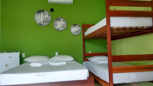 two bunk beds in a room with green walls at Dáriu's Pousada in Prea
